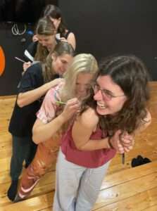 CfL Tänzerinnen schreiben einander Komplimente auf den Rücken.